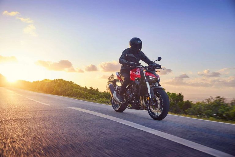 un motard qui roule avec le soleil couchant